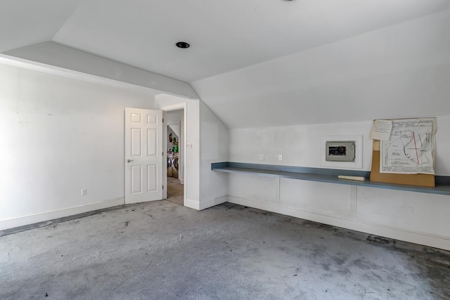 additional living space featuring concrete floors and vaulted ceiling