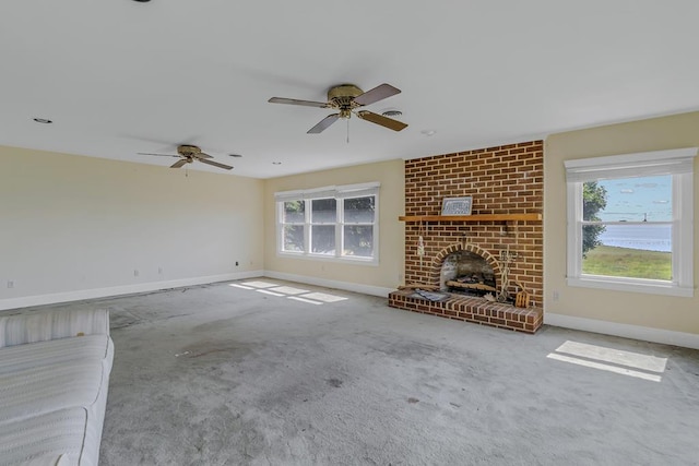 unfurnished living room with carpet, a brick fireplace, and ceiling fan