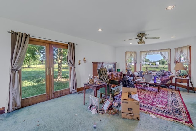 carpeted living room with ceiling fan