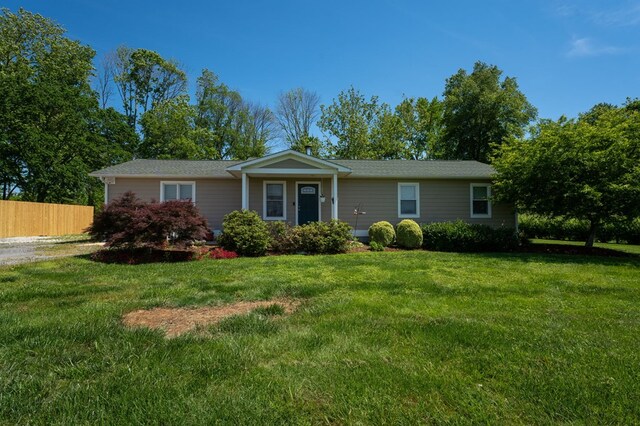 single story home with a front yard and fence