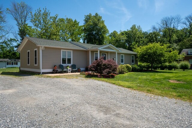 single story home with driveway and a front lawn