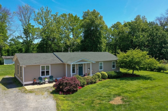 single story home featuring a front lawn and roof with shingles
