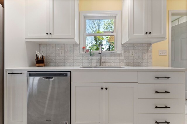 kitchen with white cabinetry, light countertops, a sink, and stainless steel dishwasher