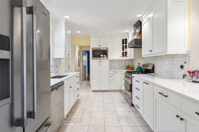 kitchen with light countertops, light tile patterned floors, a sink, white cabinets, and appliances with stainless steel finishes