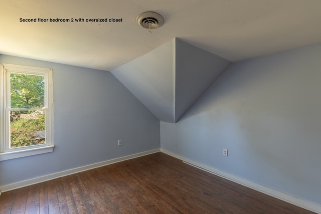 additional living space with dark hardwood / wood-style flooring and vaulted ceiling