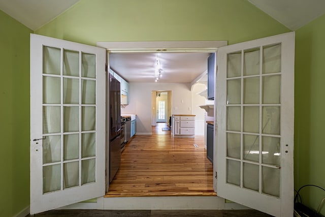 corridor featuring lofted ceiling and wood-type flooring