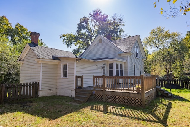 rear view of property featuring a wooden deck and a yard