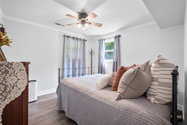 bedroom with ceiling fan, crown molding, and dark wood-type flooring