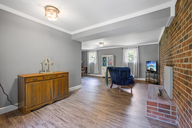 interior space with hardwood / wood-style floors, a brick fireplace, ornamental molding, and brick wall