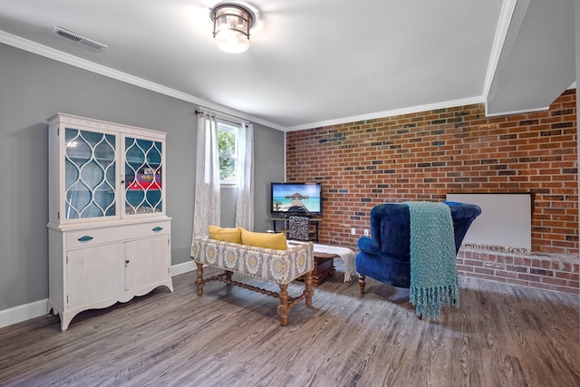 living room featuring crown molding, brick wall, and hardwood / wood-style flooring