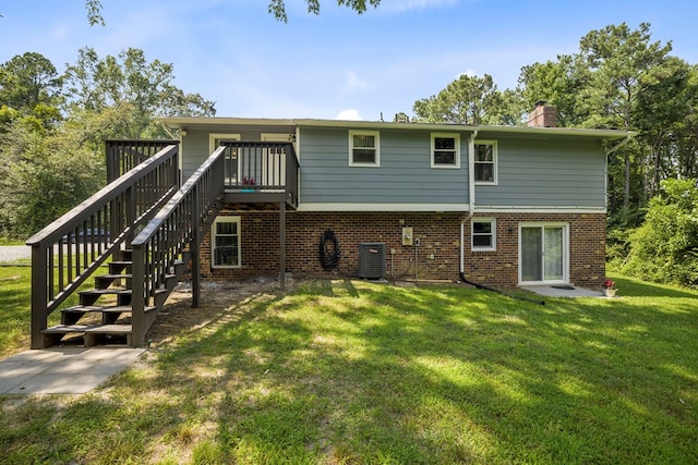 rear view of property featuring a yard, central AC, and a wooden deck