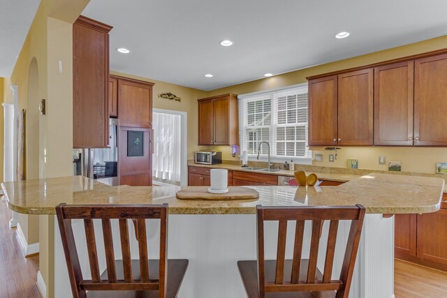 170 Rappa Run Rd, Topping, VA 23169 - kitchen with light wood-style flooring, a peninsula, a sink, light stone counters, and recessed lighting
