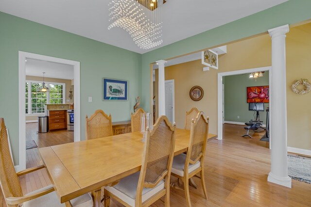 170 Rappa Run Rd, Topping, VA 23169 - dining space featuring decorative columns, light wood finished floors, a chandelier, and baseboards