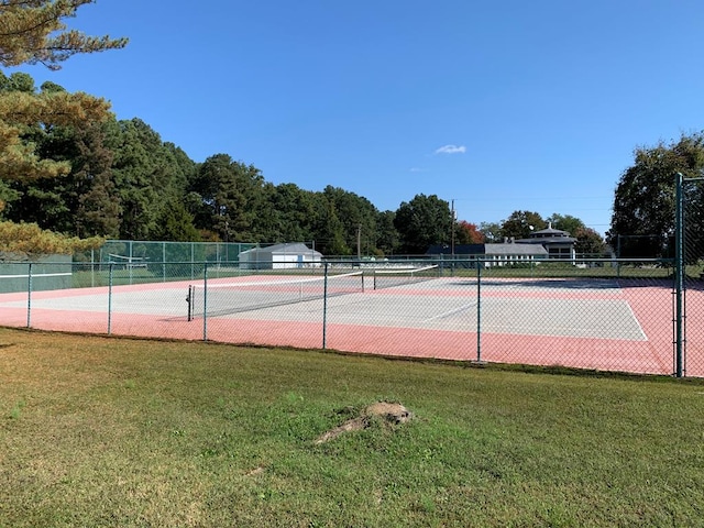 view of tennis court featuring a yard