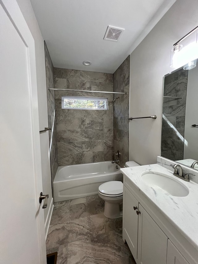 full bathroom with tiled shower / bath, vanity, and toilet