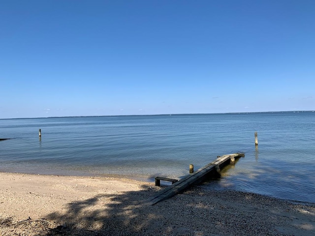 dock area with a water view and a beach view