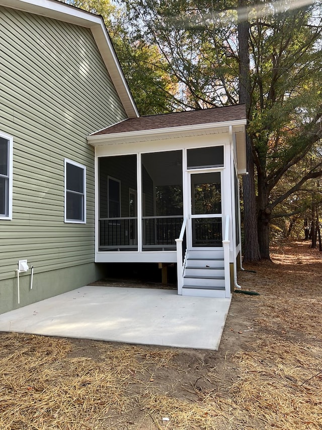 rear view of property featuring a patio and a sunroom