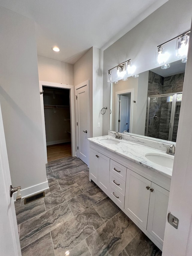 bathroom with vanity and a shower with door