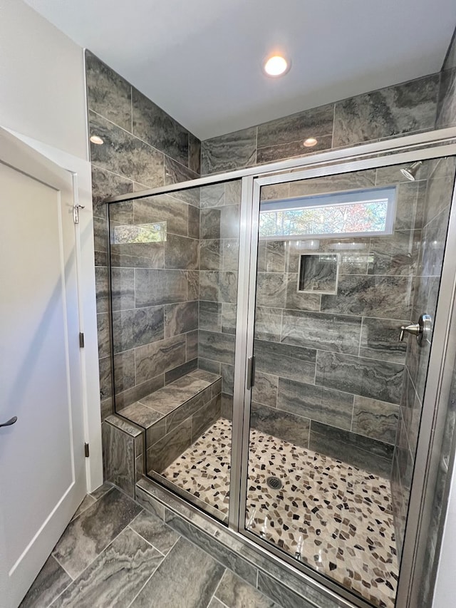 bathroom featuring a shower with door