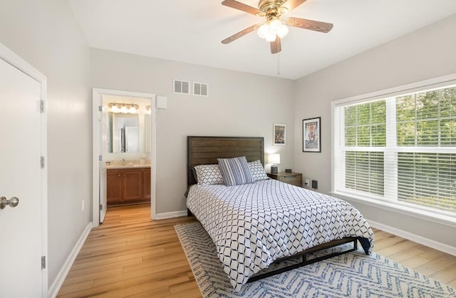 151 Bald Eagle Dr, Montross, VA 22520 - bedroom featuring light wood-style floors, a sink, baseboards, and connected bathroom