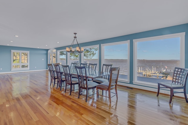 dining room with a water view and light wood-type flooring