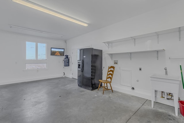 garage featuring black refrigerator with ice dispenser