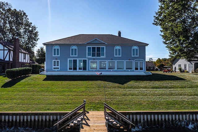 rear view of property featuring a lawn