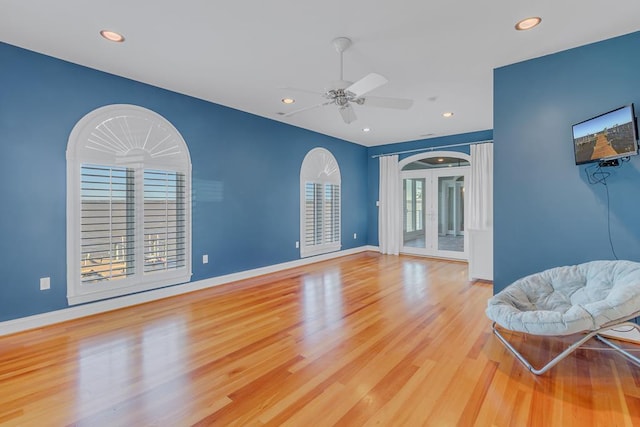 living room with ceiling fan and light hardwood / wood-style flooring