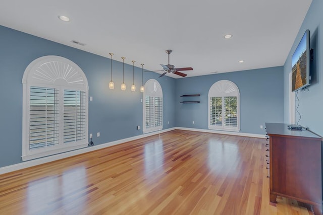 unfurnished living room featuring ceiling fan and light wood-type flooring