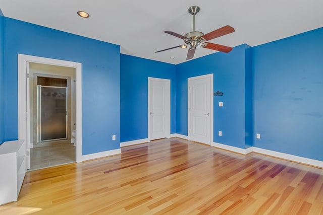 unfurnished bedroom with ensuite bath, ceiling fan, and light wood-type flooring