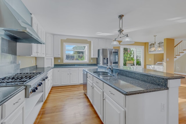 kitchen featuring sink, white cabinets, custom exhaust hood, stainless steel appliances, and a center island with sink