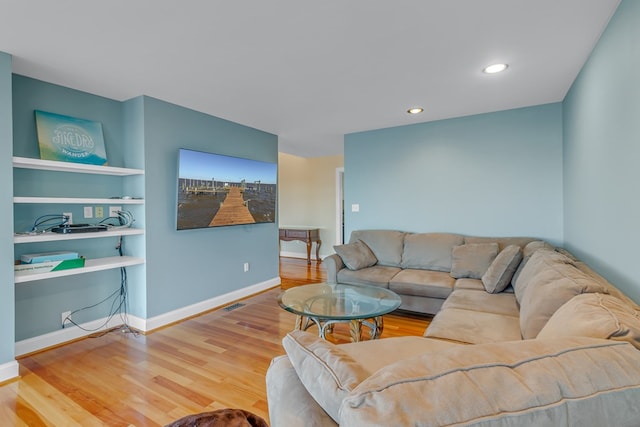 living room featuring hardwood / wood-style floors and built in shelves