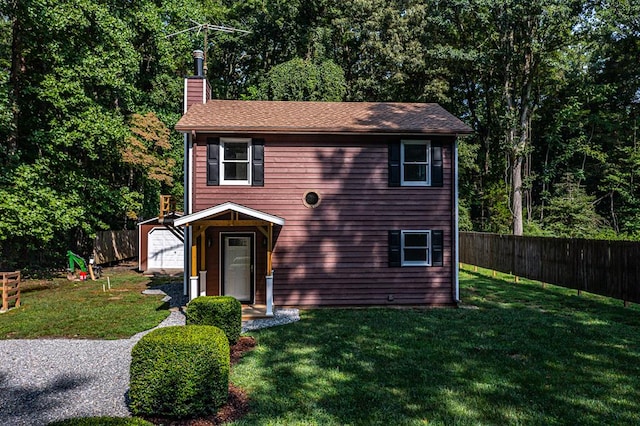 view of front of property featuring an outbuilding, a garage, and a front lawn