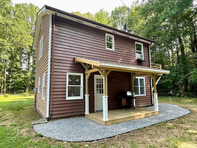 rear view of house with a yard and a deck