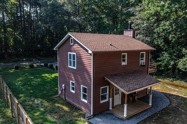 rear view of property featuring a lawn