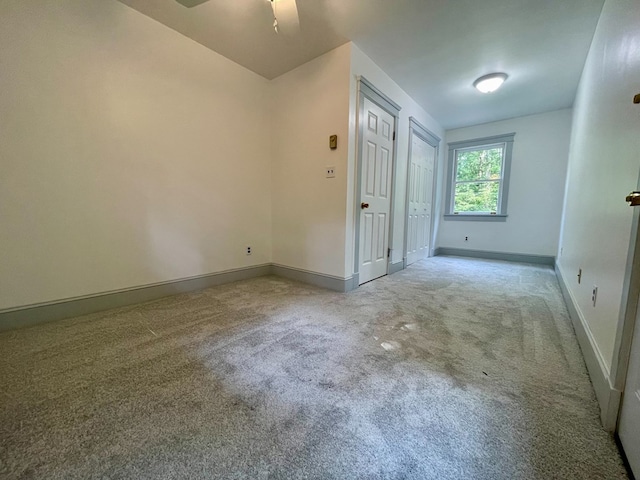 carpeted spare room with ceiling fan