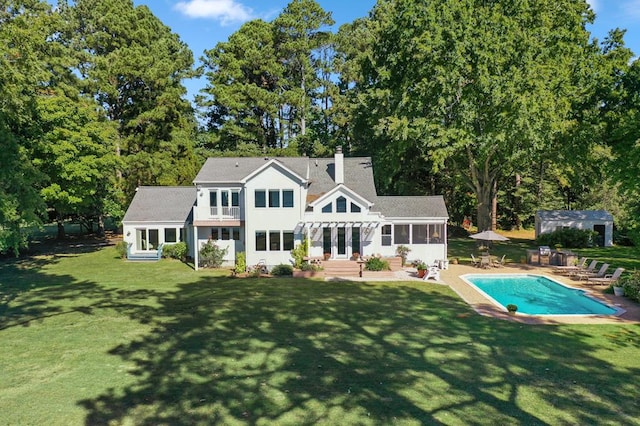 rear view of property with a patio area, a yard, and a sunroom