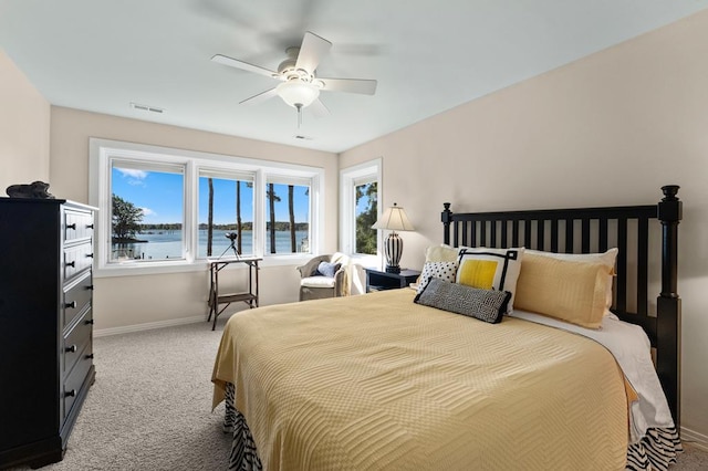 bedroom featuring carpet flooring, a water view, and ceiling fan