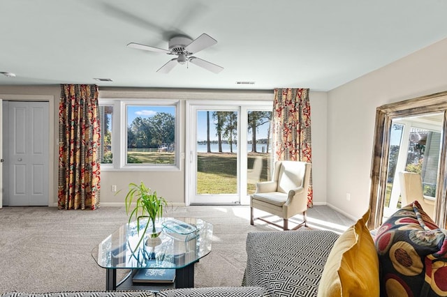 carpeted living room with ceiling fan