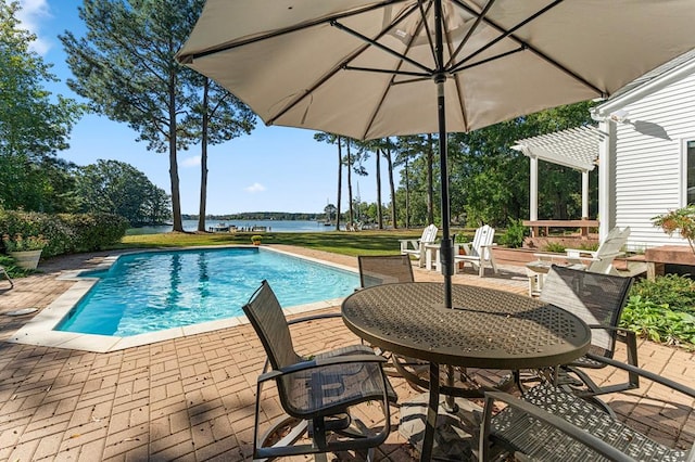 view of swimming pool featuring a patio, a water view, and a lawn