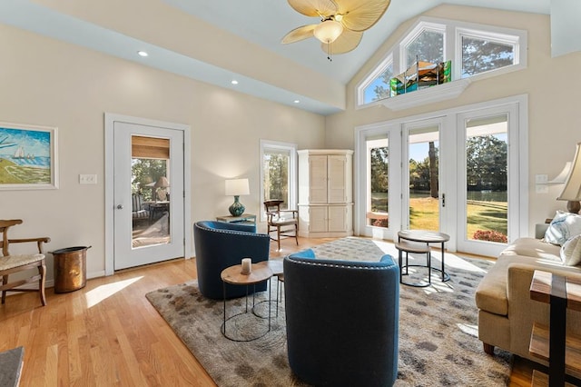 living area with light wood-type flooring, ceiling fan, high vaulted ceiling, and french doors