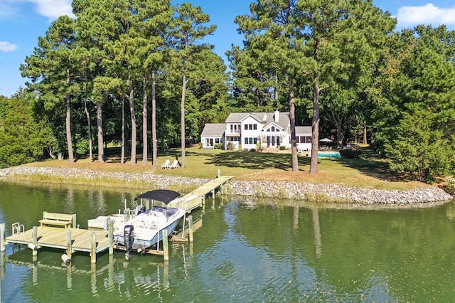 view of dock featuring a lawn and a water view