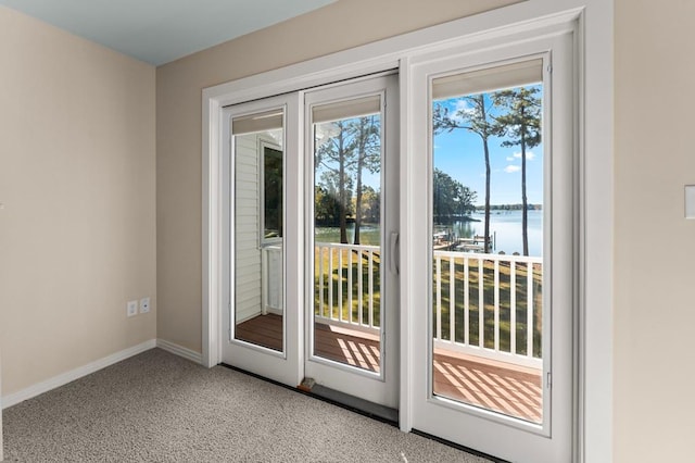 entryway featuring light carpet and a water view