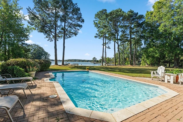 view of swimming pool with a patio, a water view, and a yard