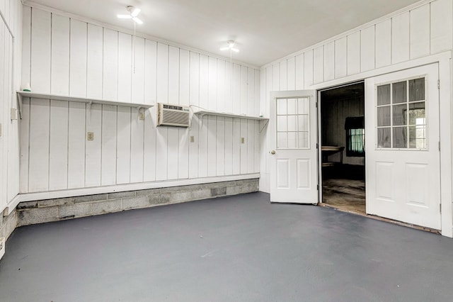 garage featuring an AC wall unit and wooden walls