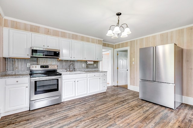 kitchen featuring light wood finished floors, stainless steel appliances, a sink, an inviting chandelier, and light countertops