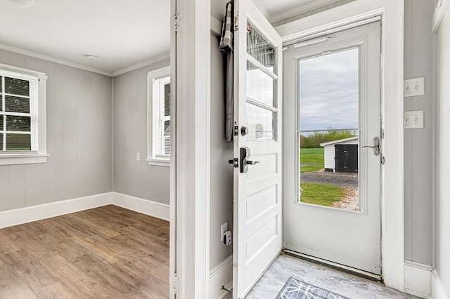 foyer featuring light wood-style floors, baseboards, and ornamental molding