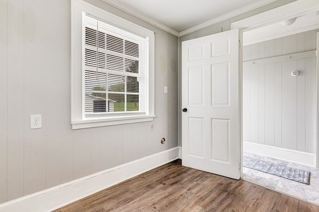 unfurnished bedroom featuring baseboards, wood finished floors, and ornamental molding