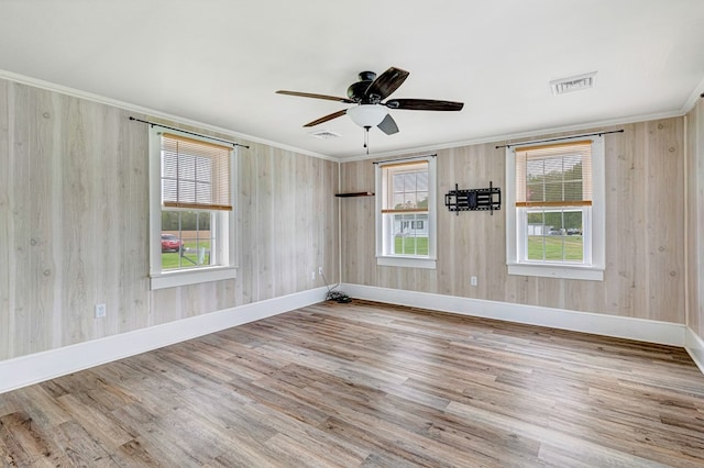 unfurnished room with visible vents, baseboards, wood finished floors, ceiling fan, and crown molding