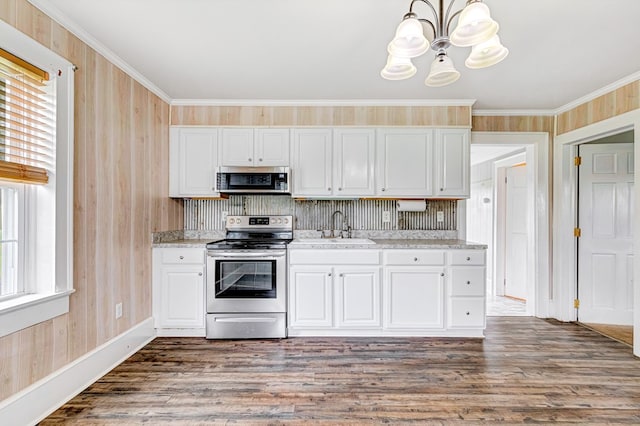 kitchen with a sink, appliances with stainless steel finishes, white cabinetry, and an inviting chandelier